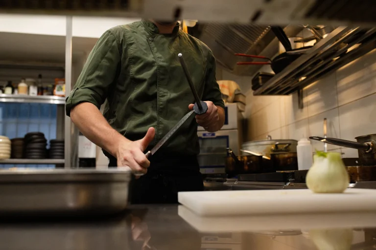 Le chef découpe un produit sur son plan de travail, en cuisine