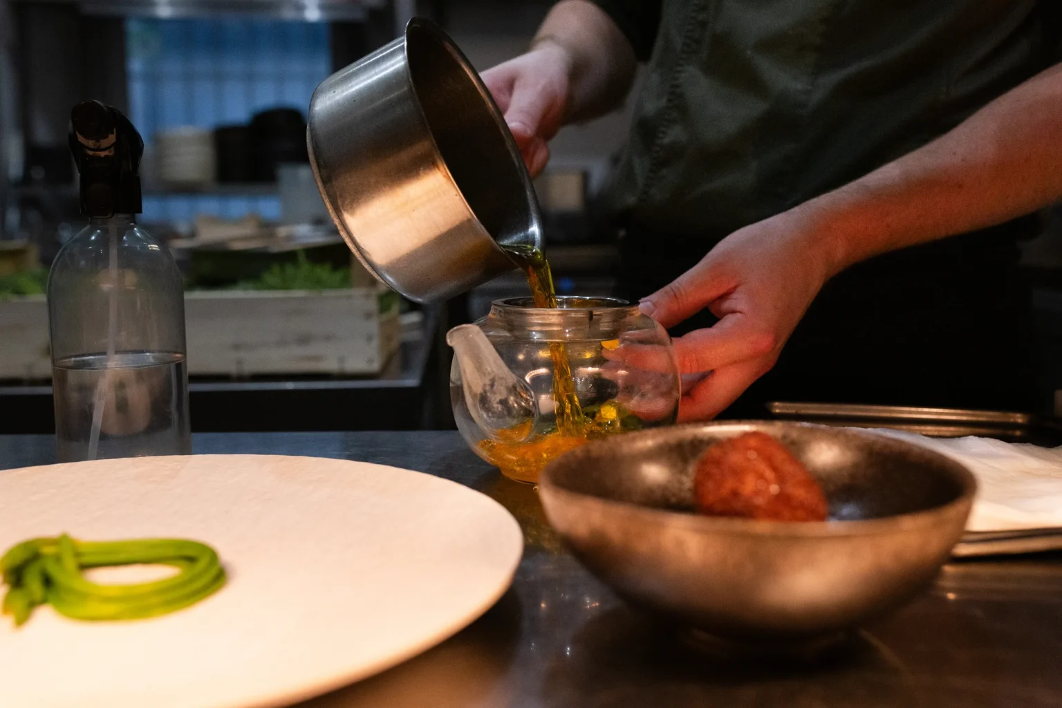 En cuisine, le bouillon est versé d'une casserole dans une théière en verre